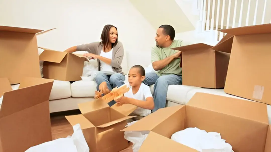 Family unpacking moving boxes in living room