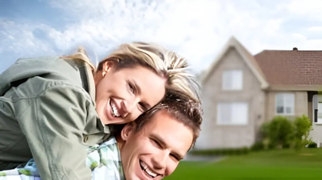 Smiling couple in front of a house.