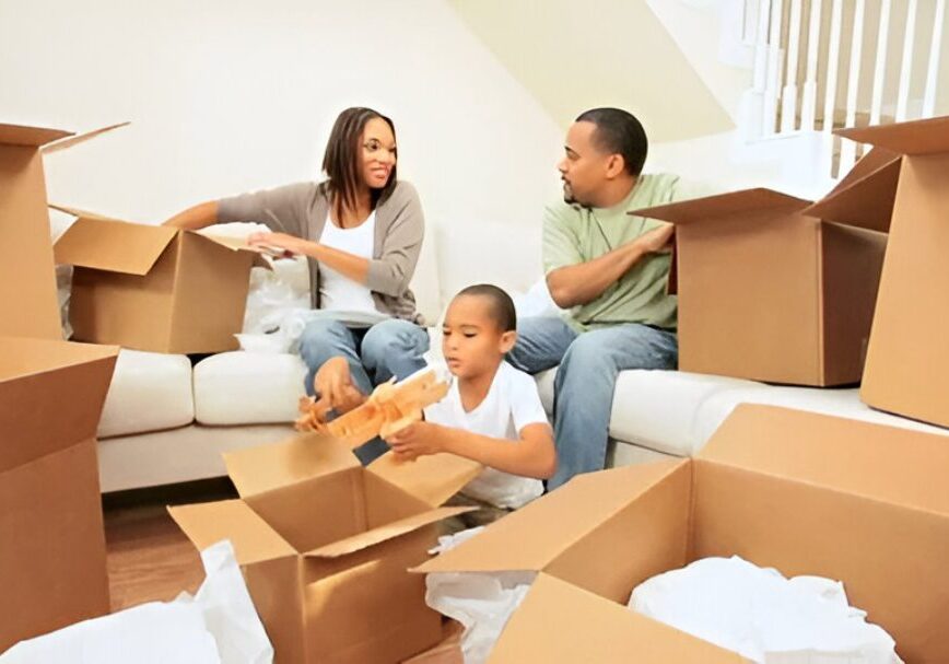 Family unpacking moving boxes in living room